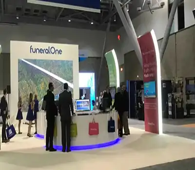 Modern trade show booth with LED arch lighting, branded signage, and AV display setup for live demos